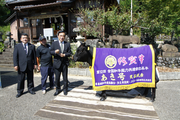 荒谷さん（左から2人目）、横尾俊彦市長（左から3人目）、野北悟市議会議長（左から1人目）、あき号