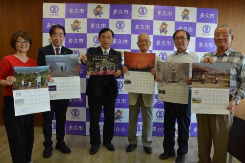 カレンダーを手にする一木会のみなさんと横尾市長、石田俊二教育長
