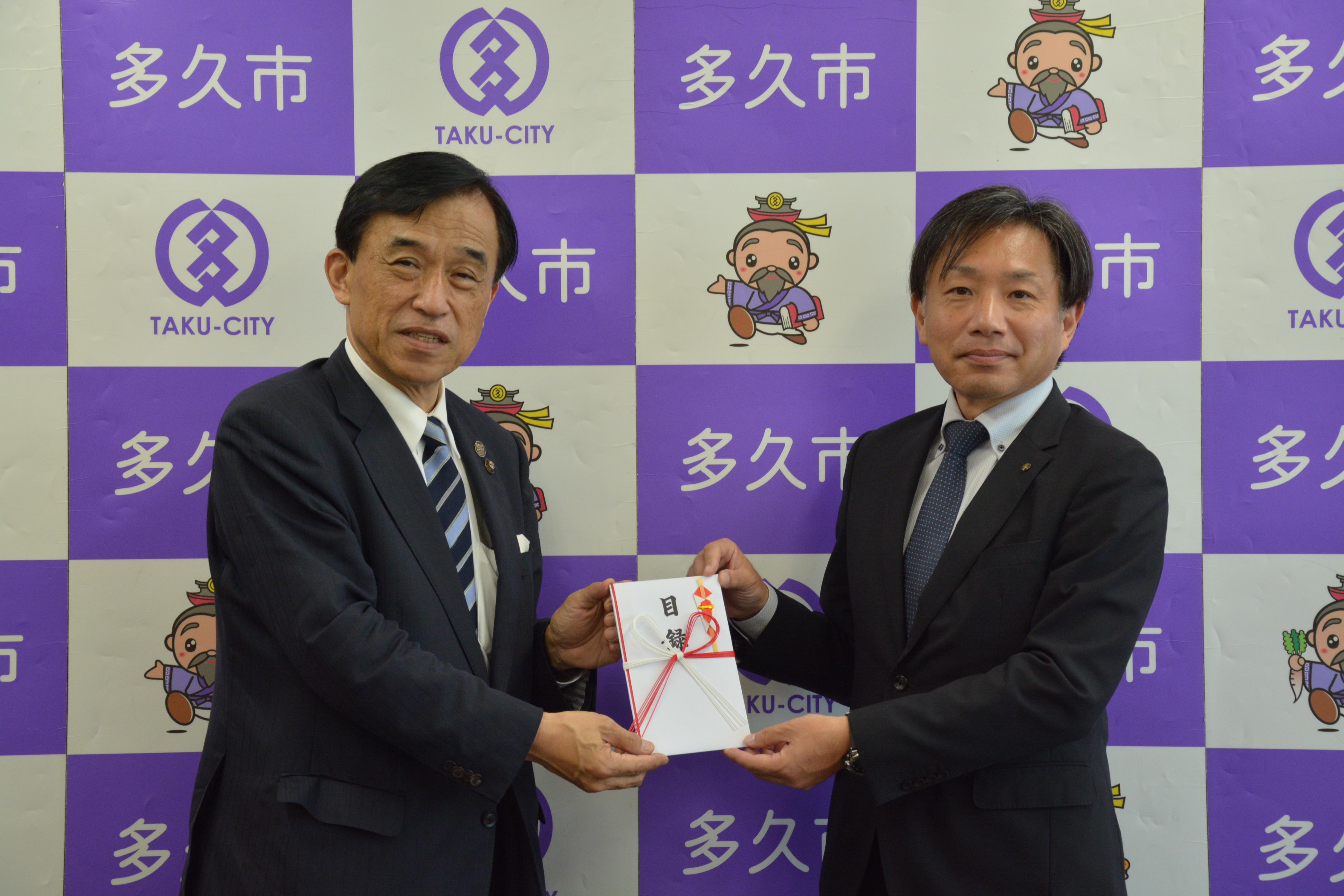 横尾市長と柿本部長が目録を持って写真撮影をしました
