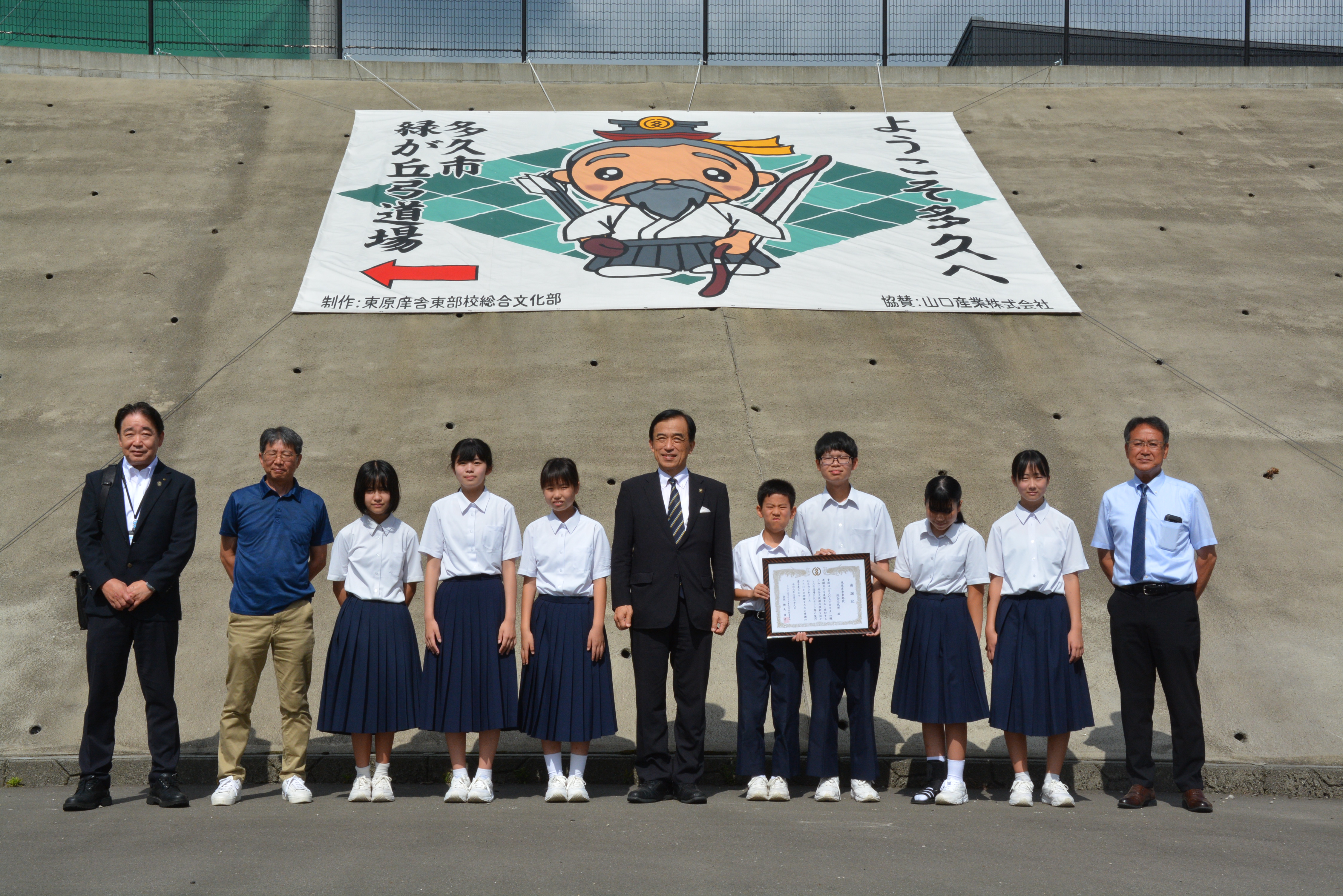 テント幕と一緒に記念写真を撮っている様子