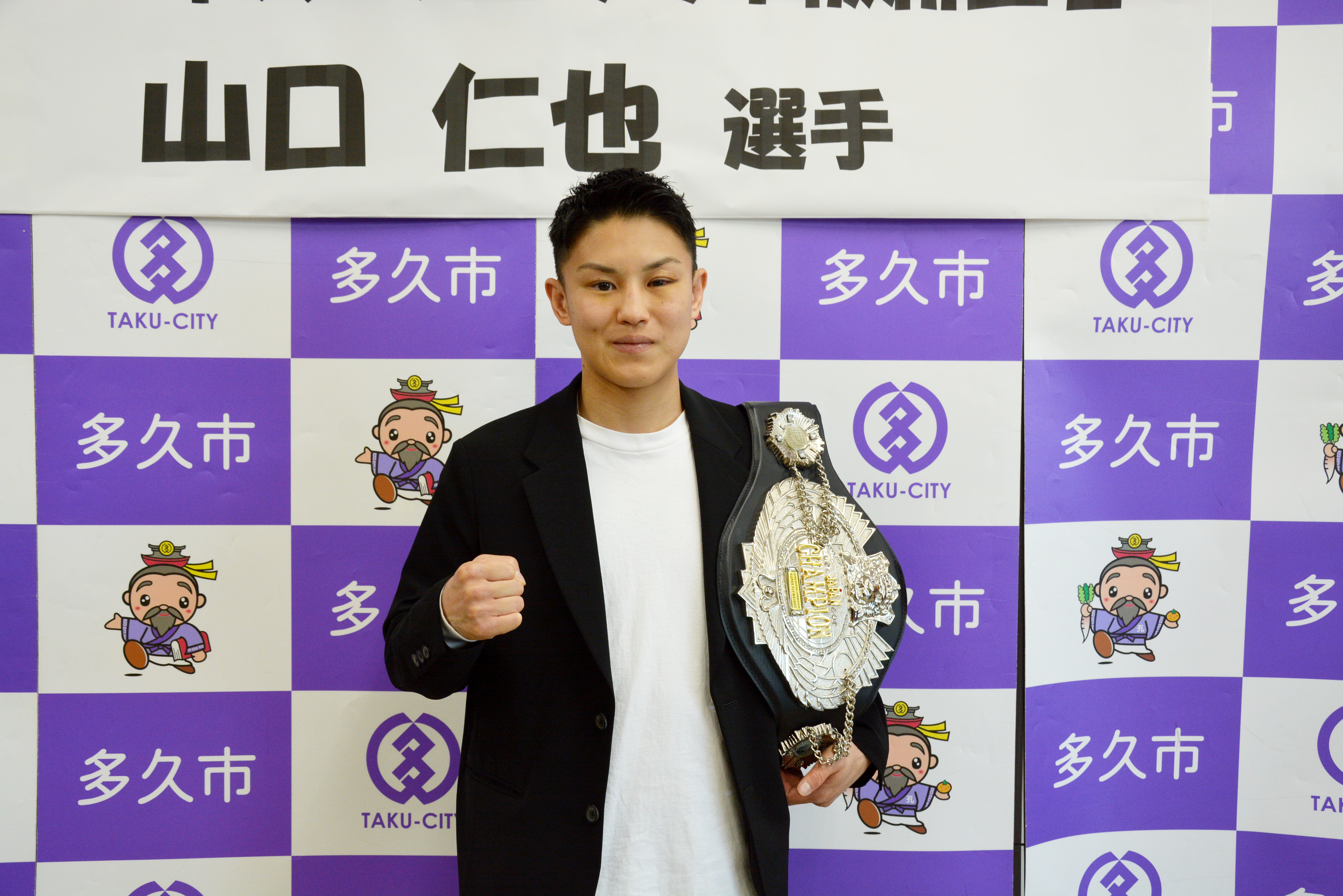 チャンピオンベルトを掲げた山口選手