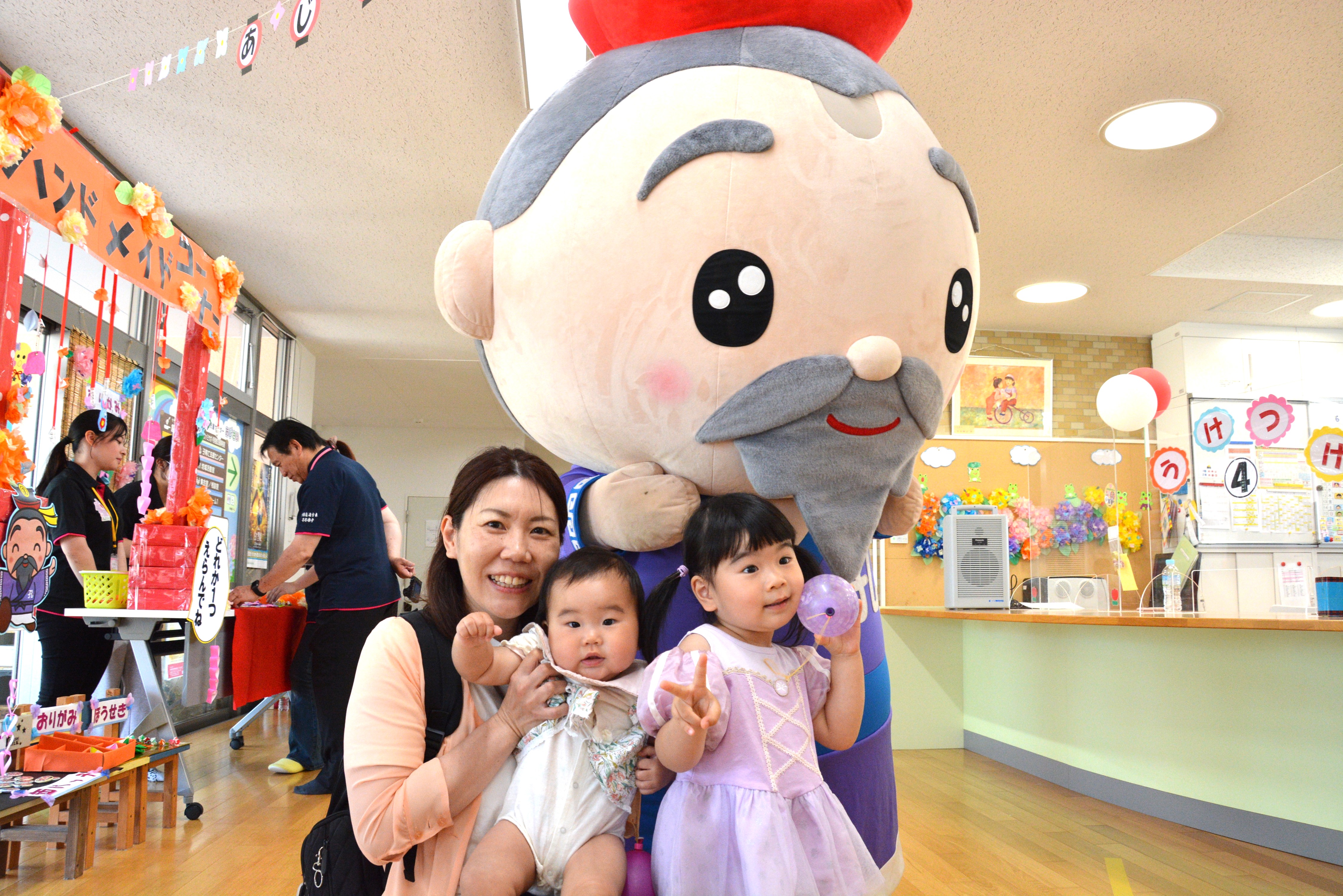 多久翁さんと一緒に記念撮影をする親子
