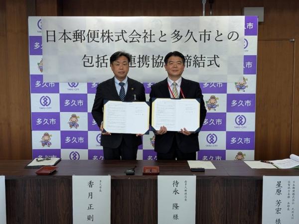 協定書を手にする香月市長と待永南多久郵便局長