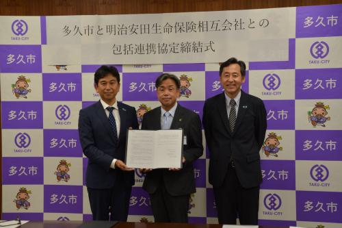 協定書を手にする香月市長ら