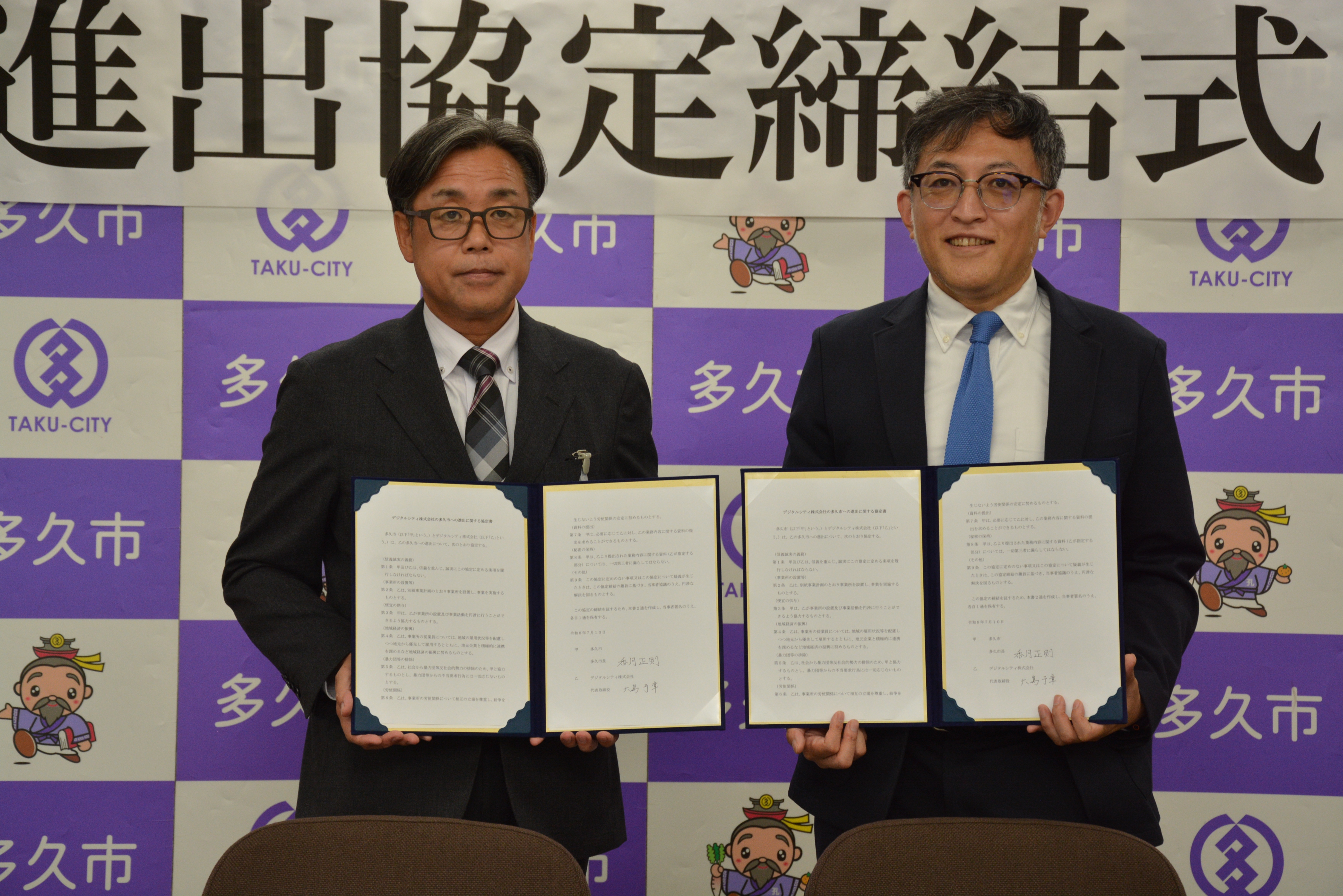 進出協定書を手にする香月市長（左）、大島予章代表取締役（右）