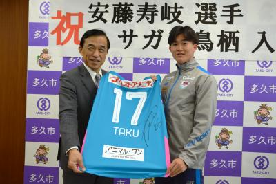 安藤選手サイン付きのユニフォームを手にした横尾市長と安藤選手
