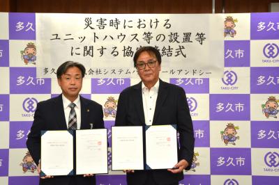 協定書を持つ左から、香月市長、木村代表取締役社長